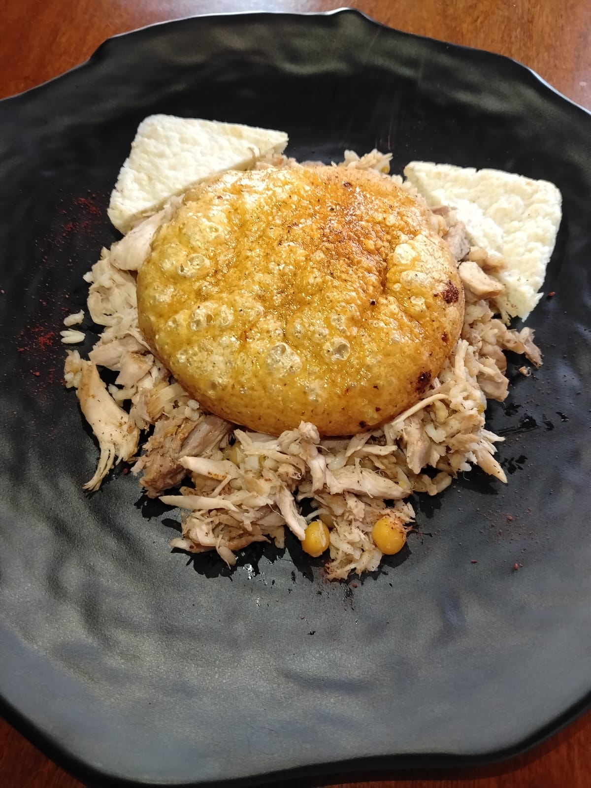 Choncito dorado y crocante sobre cama de pollo desmechado
