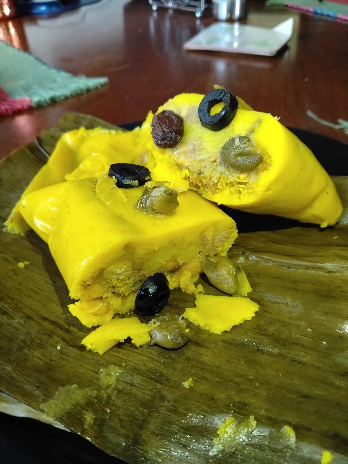 Interior de tamal con masa amarilla, carne, aceitunas y garbanzo