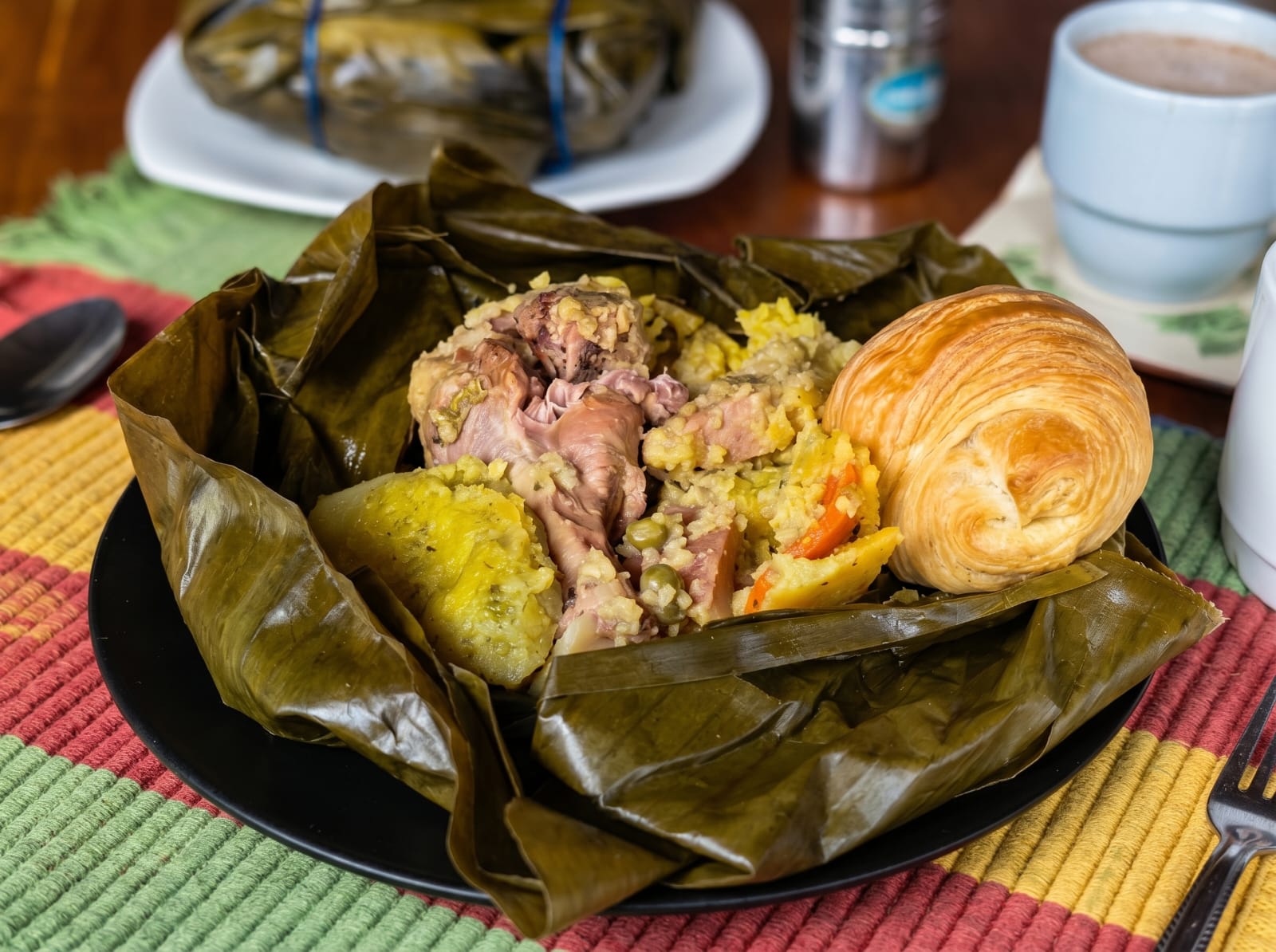 Tamal tolimense abierto en hoja de plátano con pollo, cerdo y arroz